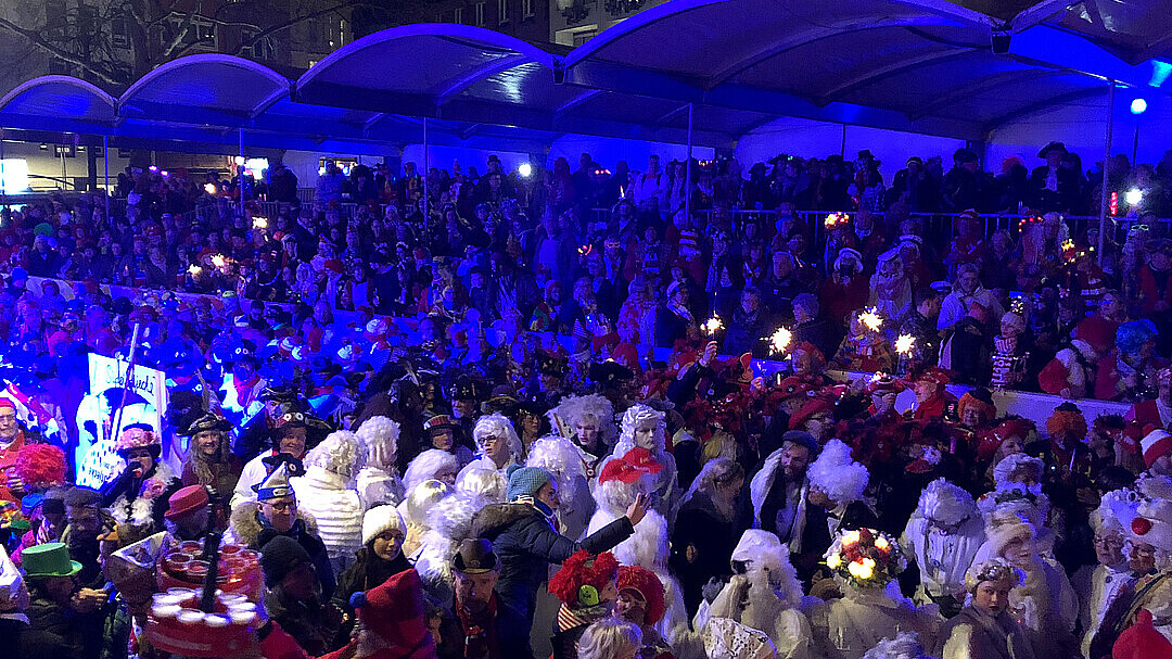 Personen auf einer Tribühne verfolgen den Zug